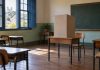 Sala de escola preparada como seção eleitoral, com cabine de votação sobre a mesa