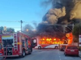 Viatura do Corpo de Bombeiros diante de ônibus em chamas em via urbana