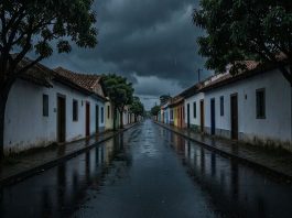 Rua de cidade do interior mineiro sob céu carregado de nuvens de chuva